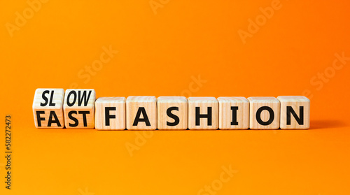 Fast or slow fashion symbol. Concept words Fast fashion and Slow fashion on wooden cubes. Beautiful orange table orange background. Business fast or slow fashion concept. Copy space.