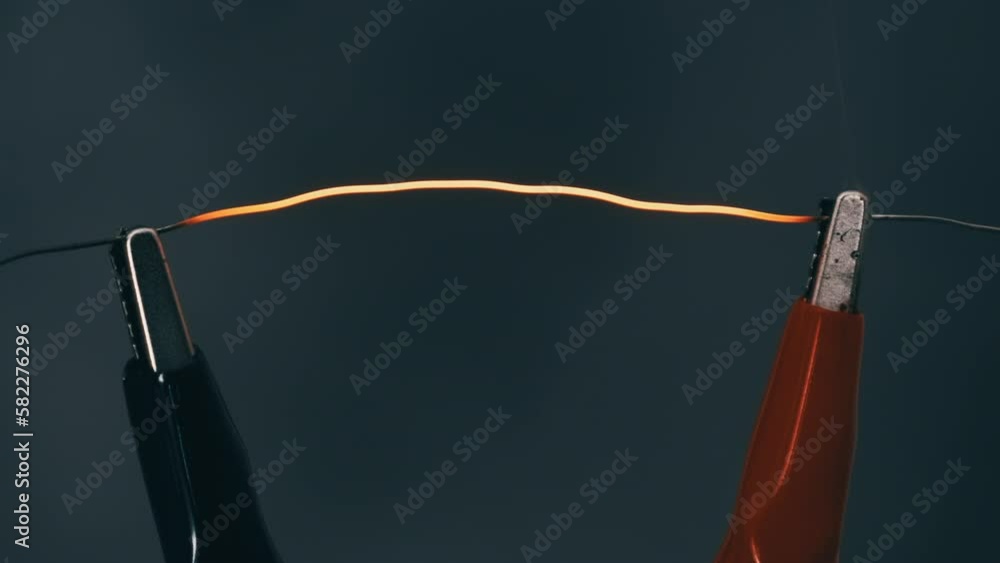 Nichrome filament connected to power wires is heated to red under high