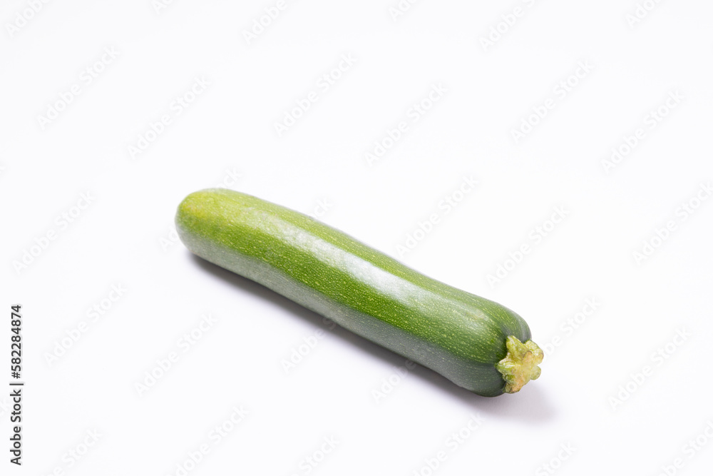 One zucchini on a white surface. One zucchini on a white surface.