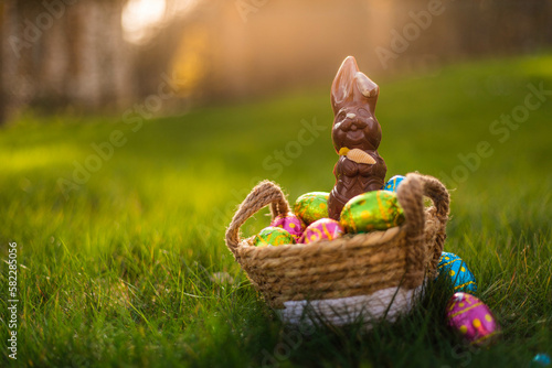Tableau sur toile Easter eggs in basket with easter bunny on top