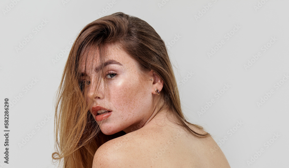 Beauty portrait of charming caucasian young woman with natural freckles on her face and shoulders Beauty portrait of charming caucasian young woman with natural freckles on her face and shoulders