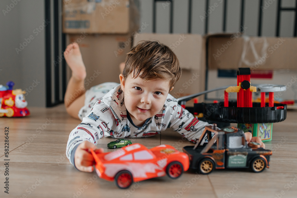 Happy kid playing with old car toy at home Happy kid playing with old car toy at home