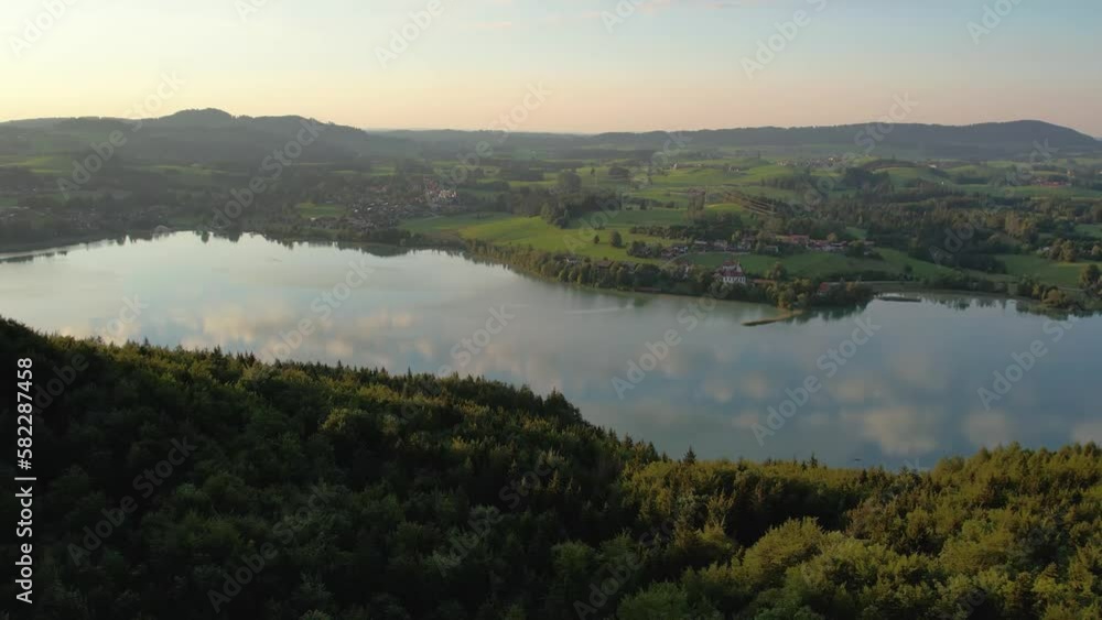 Sunset fly over mountain countryside and lake Weissensee, Germany. Wild nature and pine forest. Natural reserve Sunset fly over mountain countryside and lake Weissensee, Germany. Wild nature and pine forest. Natural reserve