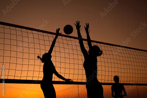 Obraz Silhouette women playing beach volleyball on sunset.