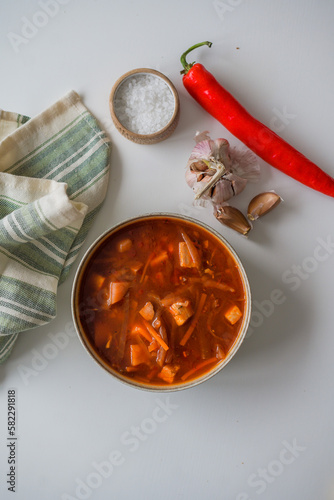 The traditional Ukrainian first course is red borsch. Hot borsch on the table with garlic, pepper and salt. Recipe for borscht made from vegetables