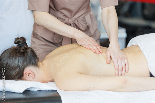 Professional massage therapist giving back massage for natural pretty woman. Natural beauty massage spa self care shot