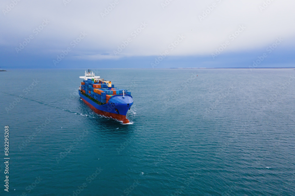 Obraz premium Container Cargo vessel underway on sea to port, aerial view