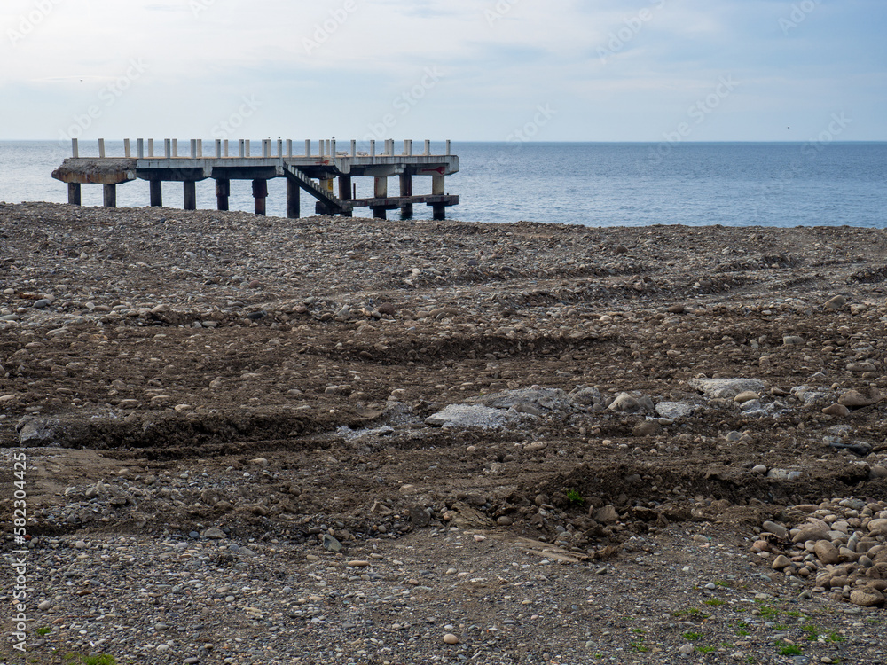 Fototapeta premium Repair of the embankment of the seaside resort. Preparing for the tourist season. Leveling the ground on the beach.