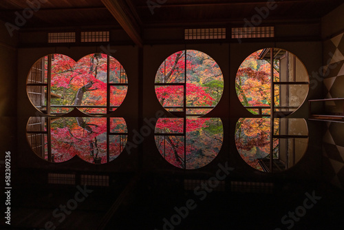 Canvas Print 日本　京都府京都市の嵯峨嵐山にある祐斎亭の丸窓の部屋の机に反射して映る雨に濡れた紅葉