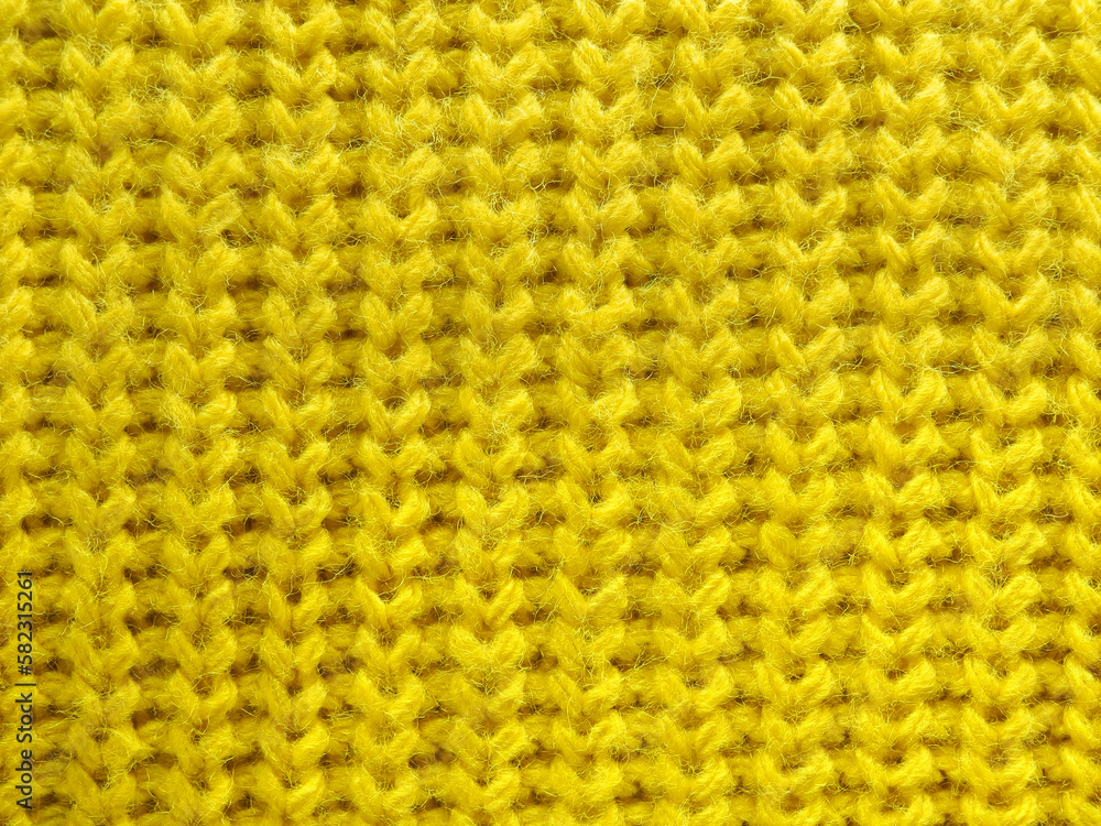 Yellow knitted wool fabric texture close-up as background Yellow knitted wool fabric texture close-up as background