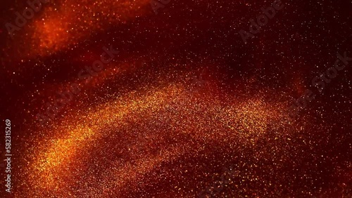 Floating Golden Dust Particles in Red Fluid. The flow and disintegration of gold particles in a red liquid. A beautiful golden glitter moving background.