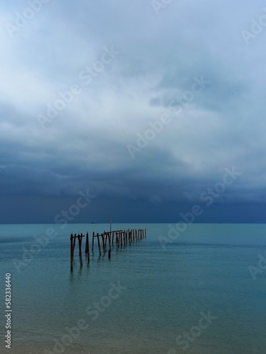 Ocean landscape with dark stormy sky and ruined jetty at Bophut beach on Koh Samui island in Thailand.
 photo