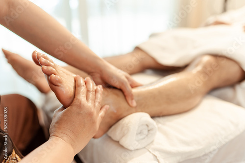 Relaxation foot massage in spa salon. Masseuse service foot massage to woman customer. Selective focus.