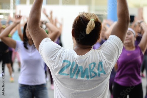 A Zumba instructor leading a crowd of women photo