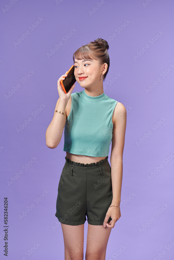 Young asian woman keeping a conversation with the mobile phone with someone Young asian woman keeping a conversation with the mobile phone with someone