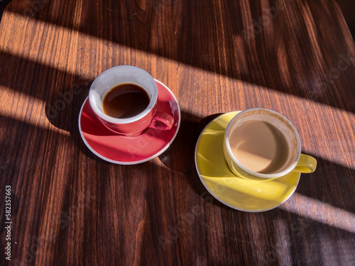 Two cups of delicious coffee on a wooden table background 