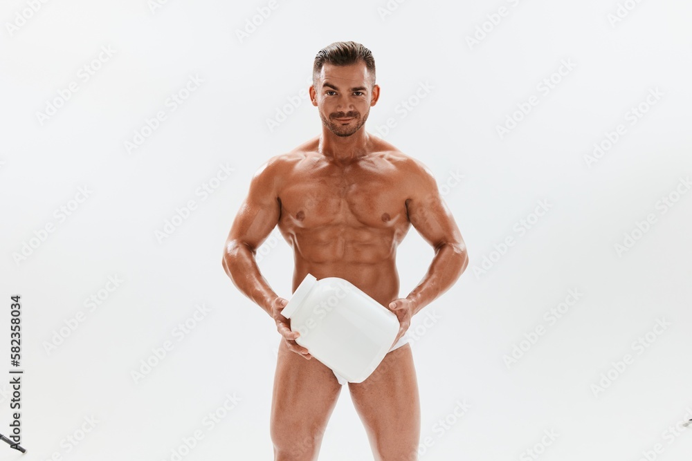 Man bodybuilder boxer with naked torso with abs holding a can of muscle growth pills, steroids, doping, protein. Advertising, sports, active lifestyle, competition, challenge concept. 