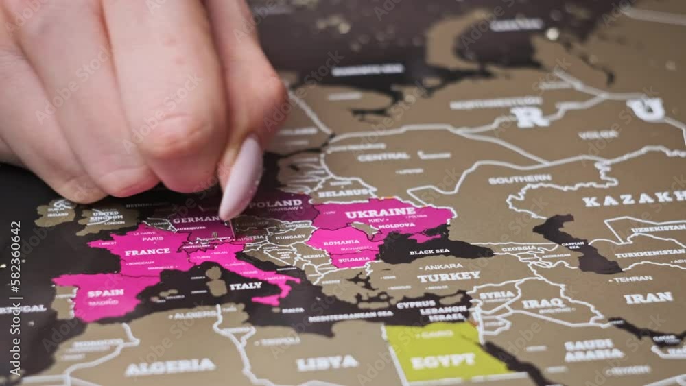 Female Hand Scratching Europe countries on the Surface of Scratch World