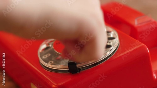 close-up of a child's hand dialing the number 911 on the disk of a vintage telephone, a child's call to the rescue service, an emergency, a child in danger photo