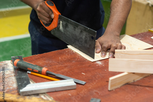 Hands of a carpenter man cutting wood photo