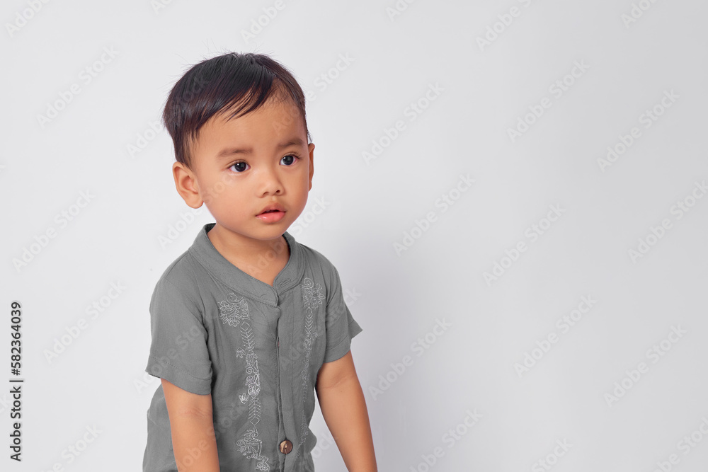 Surprised Asian muslim boy looking at copy space isolated on white studio background Surprised Asian muslim boy looking at copy space isolated on white studio background