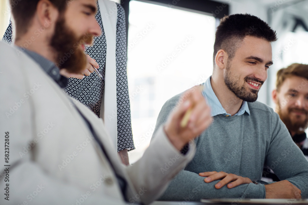 Happy businessman sitting with colleagues in board room