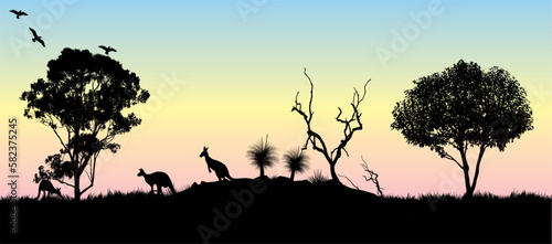 Silhouette of Gum tree and kangaroos with yellow and pink sunset