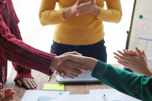 Shaking hands, Teamwork with businessman analyzing cost graphs on table at conference room.
