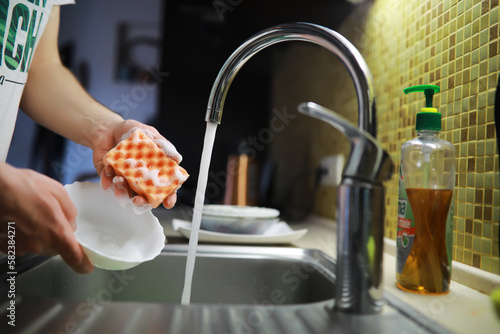 Man washing dish in sink at restaurant.People are washing the dishes too Cleaning solution