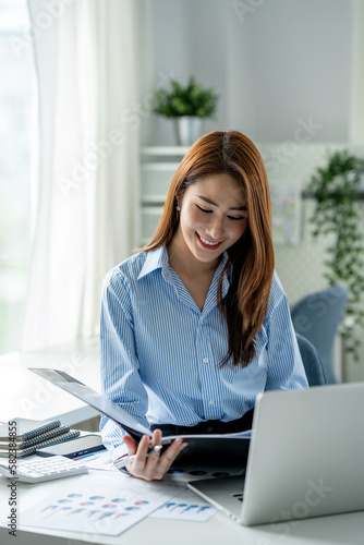 Senior executive or businesswoman looking at and examining company financial files in the real estate project division.