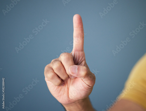 Man, hand and pointing up in studio with mockup for question, choice or vote on blue background. Product placement, finger showing deal announcement or information with mock up space for notification