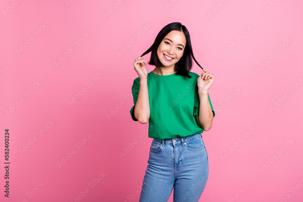 Portrait of cheerful young person beaming smile arms hold play hair isolated on pink color background Portrait of cheerful young person beaming smile arms hold play hair isolated on pink color background