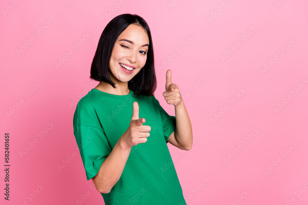 Photo of pretty positive nice girl with bob hairdo dressed green t-shirt directing at you blinking isolated on pink color background Photo of pretty positive nice girl with bob hairdo dressed green t-shirt directing at you blinking isolated on pink color background