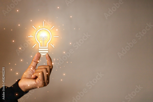 man touching a bright light bulb. Concept of Ideas for presenting new ideas Great inspiration and innovation new beginning. business studying concept.