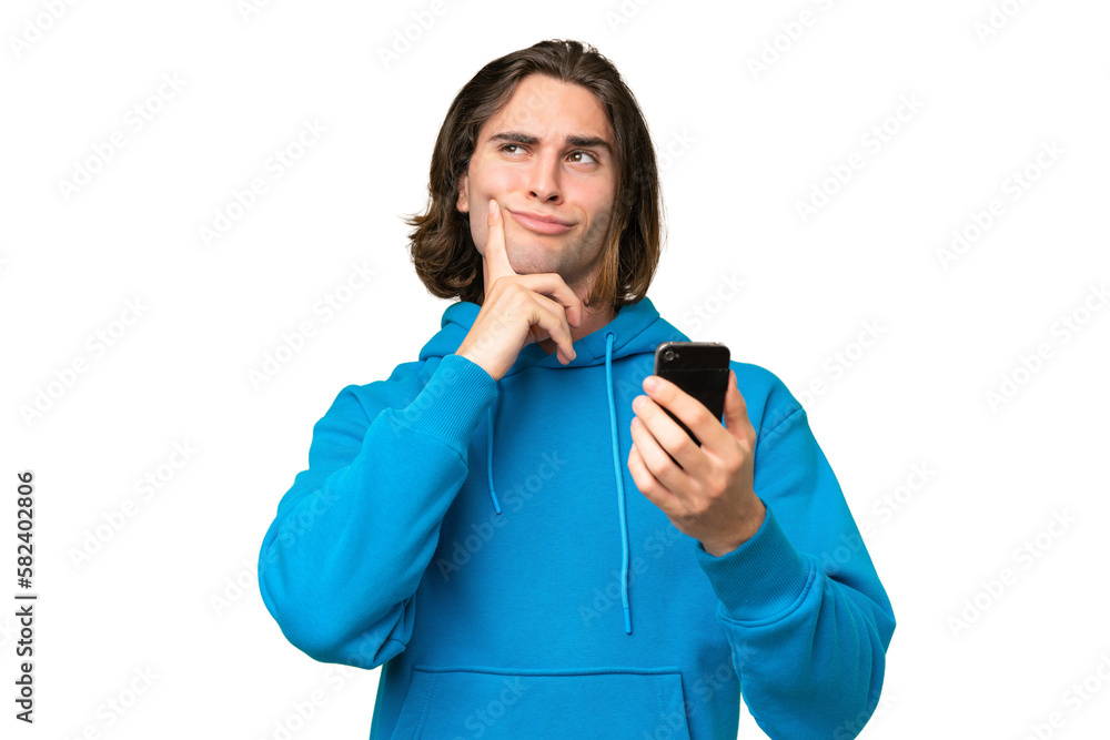 Young handsome man isolated on green chroma background using mobile phone and thinking Young handsome man isolated on green chroma background using mobile phone and thinking