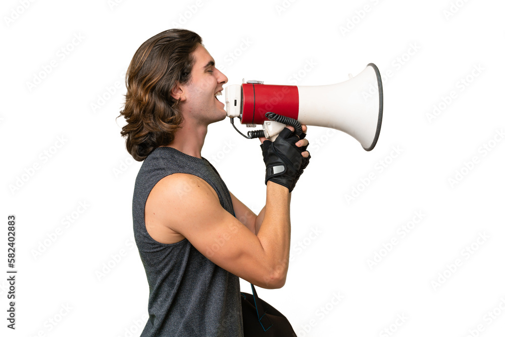 Naklejka premium Young sport handsome man isolated on green chroma background shouting through a megaphone