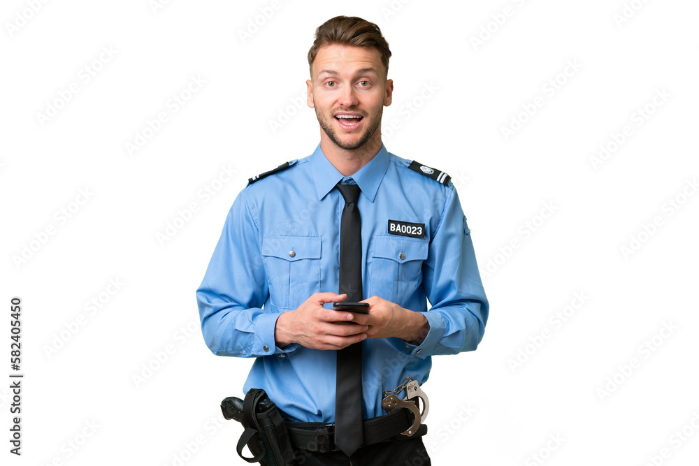Young police man over isolated background surprised and sending a message Young police man over isolated background surprised and sending a message