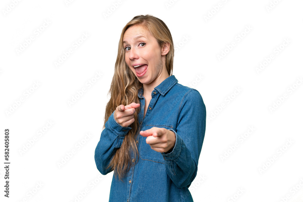 Young blonde woman over isolated background surprised and pointing front Young blonde woman over isolated background surprised and pointing front