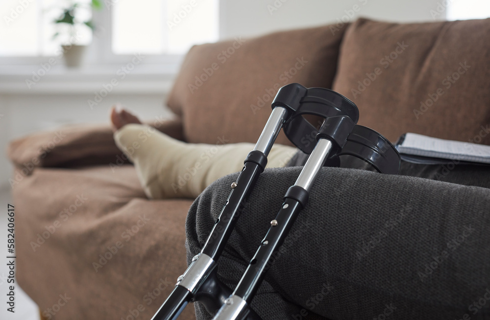 Closeup of picture of crutches against background of sitting african