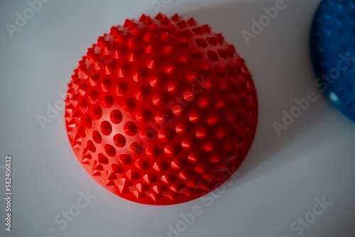 Home recreation fitness accessories. Feet physiotherapy half ball. Rubber red massage trainer.