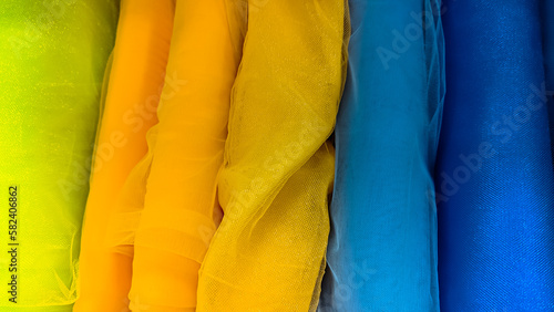 Blue and yellow fabric shades. Rolls of colorful tulle fabric in a textile shop. Silk netting. 