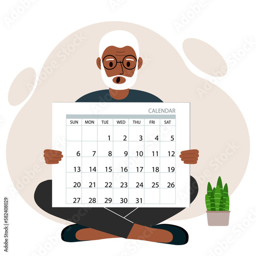 A man sits cross-legged and holds a large calendar glider in his hands. Concept of planning, make plans, schedule, event.