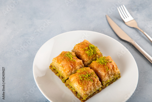 Pistachio Turkish baklava on a white plate.Close-up of four slices of baklava