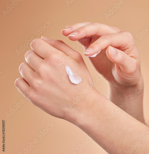Hands  skincare and beauty cream in studio isolated on a brown background. Dermatology  cosmetics and woman or female model apply lotion  creme or moisturizer product for skin health or hydration.