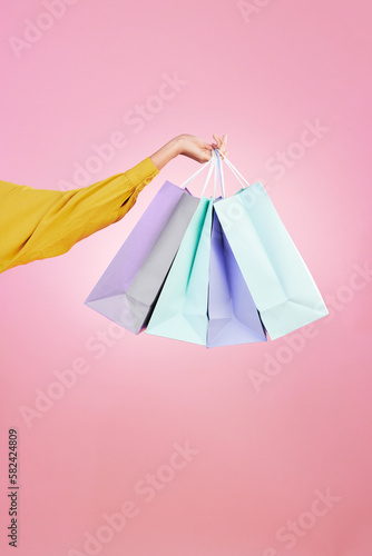 Shopping bag, studio and hands of woman, person or female with retail sales product, discount deal or mall store present. Market choice purchase, luxury designer gift and customer on pink background