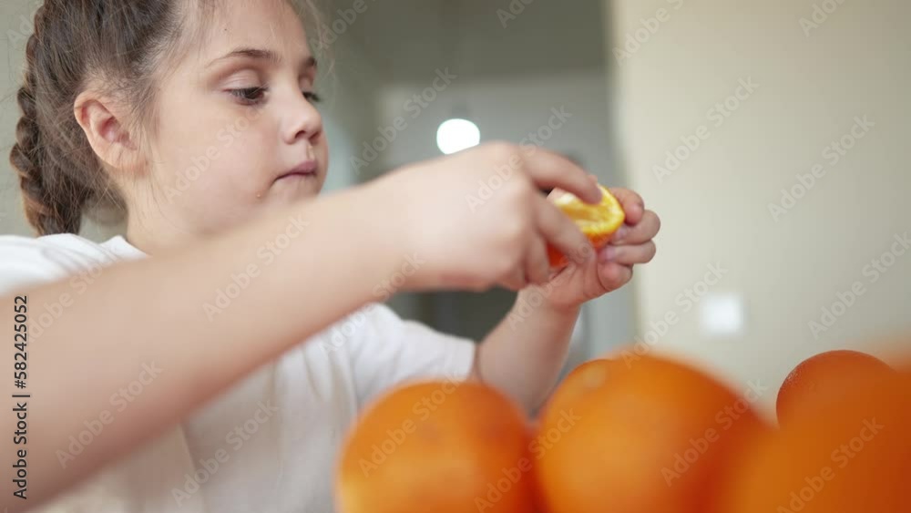 girl child eating oranges. dream happy family fruit healthy food kid concept. little girl daughter eating oranges at the table in the kitchen. juicy fruits oranges are indoor for a healthy diet girl child eating oranges. dream happy family fruit healthy food kid concept. little girl daughter eating oranges at the table in the kitchen. juicy fruits oranges are indoor for a healthy diet