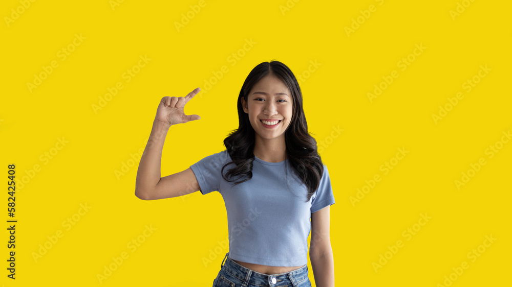 Asian woman with holding copyspace imaginary on the palm to insert an ad, Showing copyspace pointing, Showing her hand to present something on yellow background. Asian woman with holding copyspace imaginary on the palm to insert an ad, Showing copyspace pointing, Showing her hand to present something on yellow background.
