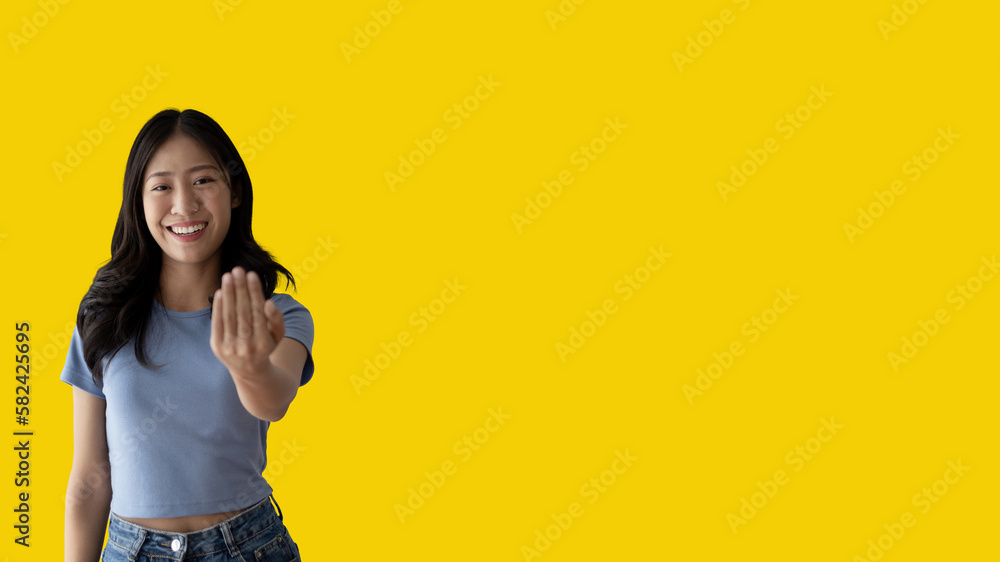 Women beckoning or inviting them to pay attention, Suggest to click or apply with me, Giving assistance and acceptance, Calling with one finger, Come and get me, Woman on yellow background. Women beckoning or inviting them to pay attention, Suggest to click or apply with me, Giving assistance and acceptance, Calling with one finger, Come and get me, Woman on yellow background.