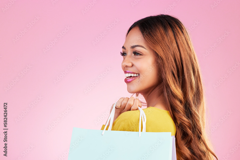 Fototapeta premium Woman, shopping bag and thinking of space in studio with a customer happy about promotion or discount. Female model or shopper on a pink background for fashion, sale and gift or surprise with a smile