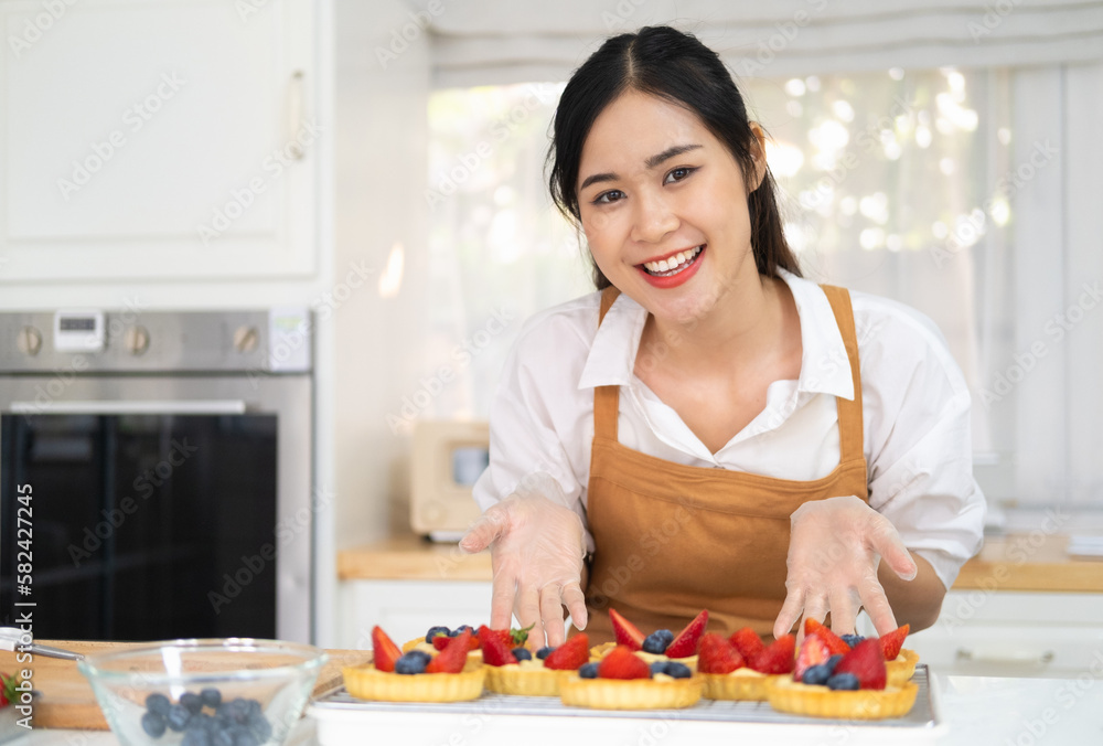 Young beautiful woman is baking in kitchen , bakery and coffee shop business. Freshly baked tart with blueberries strawberry fresh fruit. bakery and coffee shop business. Young beautiful woman is baking in kitchen , bakery and coffee shop business. Freshly baked tart with blueberries strawberry fresh fruit. bakery and coffee shop business.